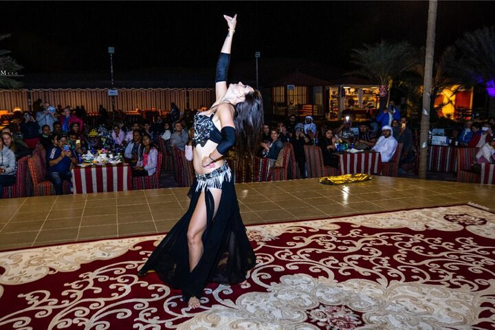 Experience the magic of traditional performances with captivating dancers surrounded by an inviting ambiance and the rich flavors of a sumptuous Arabic buffet in the Dubai desert.